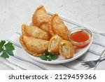 Small photo of Curry puff (kari pap ) or Pastel Goreng is Pastry Popular in Indonesia. fried pastry with filling of sauteed vegetable , chicken and boiled egg. accompanied with sauce or raw chilli pepper