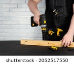 A Carpenter Drills A Hole In A...