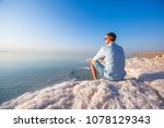 Tourist Sits On The Shore Of...