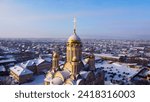 Small photo of Cityscape winter drone photo. Areal view on Cristian church in snowed town suburb. Golden cross on a roof