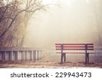 A vacant riverside bench on a foggy morning
