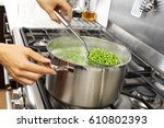 WOMAN IN KITCHEN COOKING PEAS