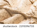 Frozen Coffee flavour gelato - full frame detail. Close up of a beige surface texture of Ice cream covered with brown coffee powder on the surface.