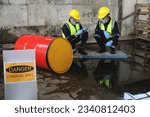 Small photo of Two Officers of Environmental Engineering Wearing Protective Equipment with Gas Masks Inspected Oil Spill Contamination in Warehouse Old, Hazardous Fuel Leakage and Environmental Concept.