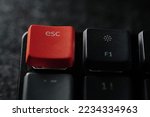 Close up of orange esc button on black keyboards.