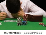 Devastated gambler man losing a lot of money playing poker in casino, gambling addiction. Divorce, loss, ruin, debt, ludopata concept