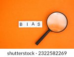 Small photo of magnifying glass and letters of the alphabet with the word BIAS. inclination or prejudice for or against one person
