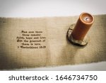 Small photo of Candle and table runner scene of 1 Corinthians 13:13 Bible verse at wedding