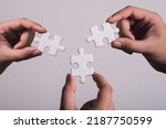 Small photo of three hands trying to connect couple puzzle piece with gray background. Jigsaw puzzle team work concept. one part of whole. symbol of association and connection. business strategy.