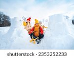 Small photo of Group of children make snowballs for snowball fights. Children play in snow fort made of ice blocks. Active winter outdoor games.