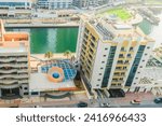 Small photo of Dubai, UAE - May 29, 2019: It is view of Dubai Marina and a rooftop of building apartment on promenade. It is Falcon hotel. It is Perl Marina hotel.