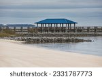 A private dock with rock jetties on the beach on the Bay of Biloxi in Ocean Springs, Mississippi.
