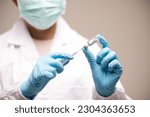 Small photo of Doctor hand in blue gloves holding influenza vaccine for prevention human.Concept fight against human papilloma virus, nurse in laboratory holding a syringe with HPV vaccines for girl and woman.
