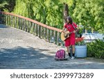 Small photo of Bucharest, Romania - June 17 2023: Street musician man playing at an acoustic guitar in King Mihai I park ( Herestrau), in Bucharest.