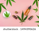 Various bottles with Full spectrum Cannabidiol CBD oils, gel lotion and Cannabis leaf on pastel pink background