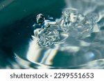 Small photo of 040.One or more drops of water splashing into waves and undefined shapes.Wallpaper.Concentric circles, madness, undefined shapes, waves, blue, green, magenta, cyan, metal, grey
