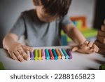 Small photo of A little boy of three years sits at a table with colored crayons and plasticine lowered his head and cries. The kid is upset and stressed. Autism Spectrum Disorder and Adjustment Difficulties