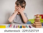 Small photo of Autism Symptoms: Lack of eye contact. Delayed development and social adaptation. Mental health therapy and socialization. Child avoids communication and make eye contact. Eyes closed with hands