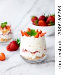 Small photo of Traditional English strawberry trifle. Individual glass with healthy dessert of yogurt, granola and fresh strawberry. Recipe of simple homemade dessert, cheesecake, mousse on low calorie diet.