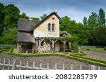 Small photo of A rustic building with reed roof, beam pergola and small garden enclosed by a wooden fence is a perfect example of what Marie Antoinette envisioned as an idyllic village.