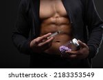 Small photo of Muscular man with a syringe in his hand. User of anabolic steroids for strength training.