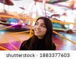 brunette girl with green eyes portrait in an amusement park, fashion photo shoot with vibrant colors and warm tones