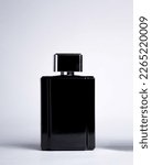 Small photo of Transparent and opaque bottle of perfume with label on a white background. Feminine and masculine essence. Studio light concept.