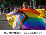 Small photo of Guy with a flag back view at pride parade, march, festival. Outdoor event celebrating lesbian, gay, bisexual, transgender, queer (LGBTQ) social self-acceptance, achievements, legal rights, and pride.