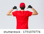 Covid-19, self-quarantine, online shopping and shipping concept. Back view of courier pointing at his t-shirt to show carrier company logo, courier promote service of delivery during coronavirus