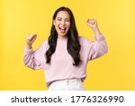 Small photo of Lifestyle, emotions and advertisement concept. Happy smiling and pumped asian girl celebrating victory, chanting yes with hands raised up and broad grin, triumphing over achievement or success