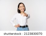 Its you. Beautiful young asian woman, company manager pointing finger at camera and smiling, choosing, inviting people, recruiting, standing over white background