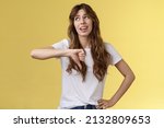 Small photo of Blah blah boring. Unimpressed apathetic snobbish attractive curly-haired girl look away express scorn disdain show thumb down frowning sharing negative judgement bad opinion yellow background
