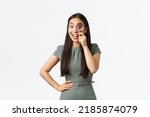 Small photo of Small business owners, women entrepreneurs concept. Excited happy asian woman found something good, looking through magnifying glass with pleased smile, searching for product, white background