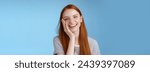 Small photo of Charismatic talkative friendly-looking happy laughing redhead girl having fun discuss previous summer holidays make jokes chuckling touching face amused standing cheerful blue background.
