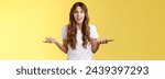 Small photo of Pissed frustrated bothered curly-haired caucasian girl stare camera puzzled complain hold smartphone shrugging spread hands sideways dismay arguing after intense serious phonecall yellow background.