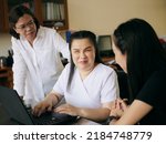 Small photo of Asian women co-workers in workplace including person with blindness disability using laptop computer with screen reader program for visual impairment people. Disability inclusion at work concepts.