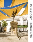 Small photo of Villanova de la Serena, Spain - 26 June 2022: Square with shade cloths and statue to Pietro de Valdivia in Villanova de la Serena (Spain)