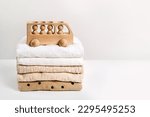 Small photo of Stack of baby clothes with wooden toy car. Cotton clothes and muslin swaddle blanket in pastel colors. Clean freshly laundered, neatly folded kids clothes.