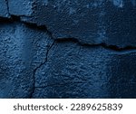Black dark navy blue texture background for design. Toned rough concrete surface. A painted old building wall with cracks. Close-up. Distressed, broken, crushed, collapsed, destruction. High quality