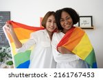 Diversity African American  Asian Married couples Lesbian LGBTQ.Engaged homosexual Hug together Rainbow flag.Sexual equality,LGBT Pride month,Parade celebrations concept.Family of happiness smiling.