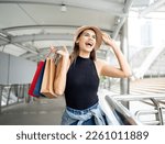 Woman holding a shopping paper bag. Happy woman with shopping bags enjoying in shopping. Consumerism, shopping, lifestyle concept.