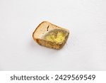 Small photo of Moldy bread. Wasted, spoiled and moldy food on a gray background. Refusal to eat, irrational consumption.