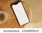 Modern smart phone mock-up, mobile phone with white empty screen on the wooden table, top view