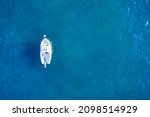 Empty fishing boat from above in atlantic. Aerial view of small white ship on blue sea water. Isolated object.