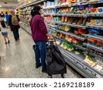 Small photo of London. UK- 06.19.2022. Customers in a supermarket making careful choices as food inflation hit a record high.