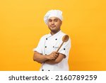 Small photo of Young handsome asian man chef in uniform with hat holding ladle utensils cooking in the kitchen various gesture action on isolated yellow background. Indian man Occupation chef restaurant and hotel.