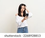 Small photo of Pretty young asian woman using smartphone feeling upset confused bad depressed emotional standing on isolated white background. Holding cell phone. Thinking and stressed