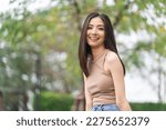 Happy feeling of Beautiful Young Woman smiling outdoor in sunlight. Pretty attractive face of female and beautiful smile. She is positive thinking and successful.