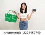 Small photo of Happy beautiful woman holding shopping basket going to shopping. Using smartphone choose category for shopping online. Application shopping online buy and payment on cell phone.