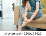 Small photo of Close up woman leg knee pain feet. Female pain with ankle because walk too much. Massaging suffering knee foot. Pain at calves sitting on couch at home. Hands massage legs on sofa.